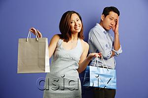 AsiaPix - Smiling woman holding shopping bags, man behind her with hand on head