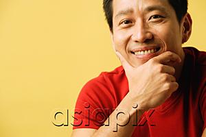 AsiaPix - Man smiling at camera, hand on chin