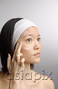 AsiaPix - Woman applying moisturizer