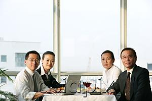 AsiaPix - Executives sitting at lunch table, looking at camera