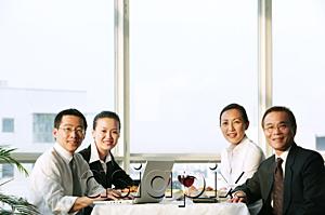 AsiaPix - Executives sitting at lunch table, smiling at camera