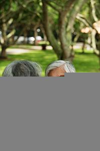 AsiaPix - Mature couple sitting in park, facing each other, man smiling