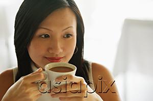AsiaPix - Young woman, holding cup of coffee, looking away