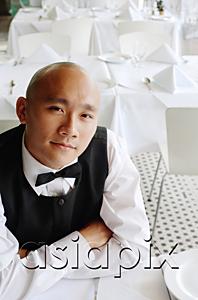 AsiaPix - Waiter sitting at table, arms crossed, looking at camera