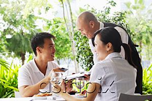 AsiaPix - Couple in restaurant, man giving waiter credit card