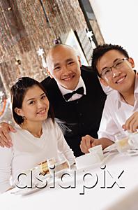 AsiaPix - Waiter and customers at restaurant, looking at camera, portrait