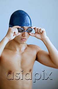 AsiaPix - Man adjusting goggles, wearing swimming cap