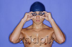 AsiaPix - Man with swimming cap and goggles, adjusting goggles, looking at camera
