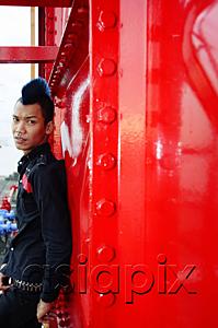 AsiaPix - Man with mohawk, leaning on wall, looking at camera