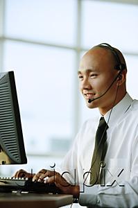 AsiaPix - Man with headset, in front of computer, smiling