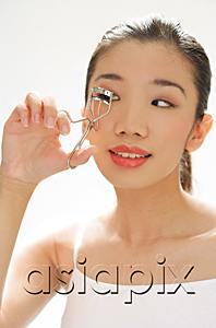 AsiaPix - Woman using eyelash curler