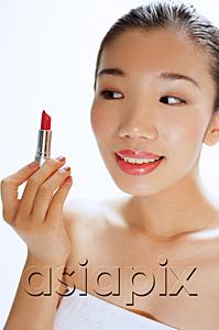 AsiaPix - Woman looking at lipstick in her hand