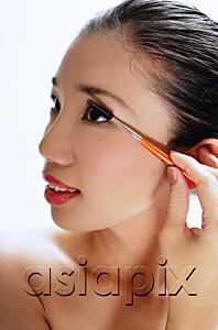 AsiaPix - Woman applying mascara, looking away