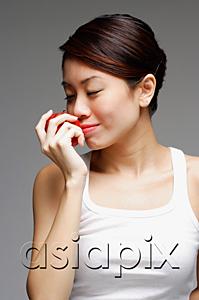 AsiaPix - Woman holding apple, to her nose