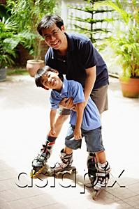AsiaPix - Father and son standing, wearing in-line skates, looking at camera