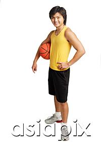 AsiaPix - Man holding basketball under arm, hand on hip, looking at camera