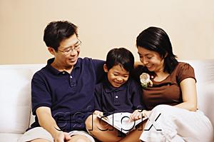 AsiaPix - Family with one son, sitting on sofa, looking at book