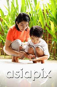 AsiaPix - Mother and son crouching, son holding terrapin