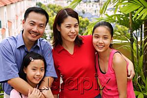 AsiaPix - Family standing on balcony, smiling at camera, portrait