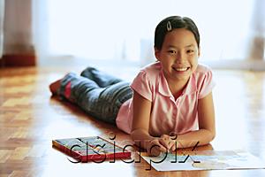 AsiaPix - Girl lying on floor, with paper and crayons, looking at camera, smiling