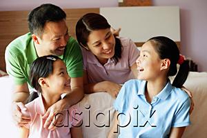 AsiaPix - Father and mother with two daughters in bedroom