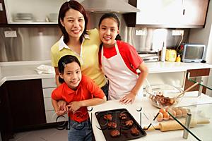 AsiaPix - Mother and two daughters in kitchen, looking at camera