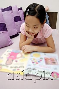 AsiaPix - Girl reading magazine, lying on front