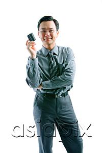 AsiaPix - Businessman holding credit card, arms crossed, looking at camera