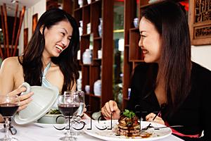 AsiaPix - Women in restaurant, sitting at table with food