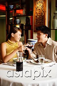 AsiaPix - Couple toasting with wine glasses in Chinese restaurant