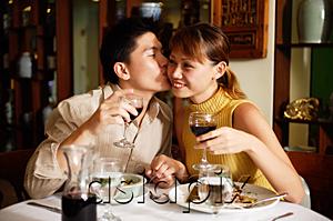 AsiaPix - Couple in Chinese restaurant, holding wine glasses, man kissing woman on cheek