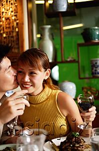 AsiaPix - Man kissing woman on cheek in restaurant