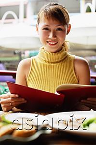 AsiaPix - Woman in cafe, holding menu, looking at camera, smiling