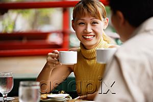 AsiaPix - Couple in cafe, holding cups, woman smiling