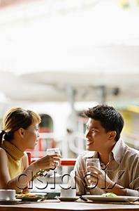 AsiaPix - Couple in cafe, sitting side by side, holding glasses of water