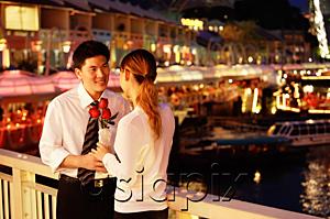 AsiaPix - Man and woman standing face to face, woman holding roses