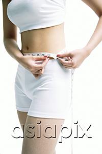 AsiaPix - Woman holding tape measure around her waist