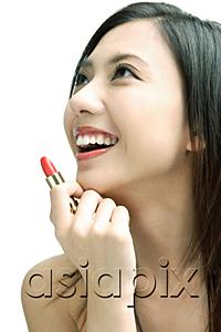 AsiaPix - Woman smiling looking away, holding lipstick
