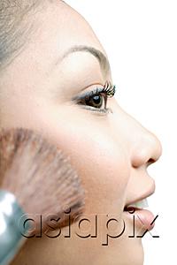 AsiaPix - Woman applying blusher with make-up brush, profile