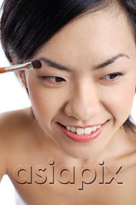 AsiaPix - Woman applying eyeshadow