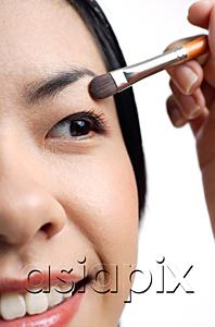AsiaPix - Woman applying eyeshadow, close-up