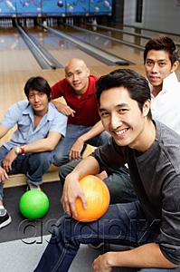 AsiaPix - Four men in bowling alley, smiling at camera