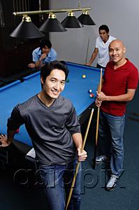 AsiaPix - Four men standing around pool table, looking at camera