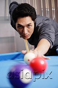 AsiaPix - Man holding pool cue, aiming at ball