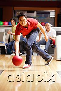 AsiaPix - Man bowling, friends watching in the background