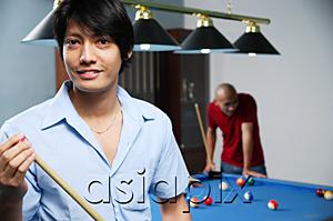 AsiaPix - Man holding pool cue, smiling at camera