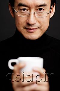 AsiaPix - Man with glasses, holding mug, black background