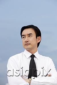 AsiaPix - Businessman with arms crossed, looking away