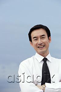 AsiaPix - Businessman with arms crossed, smiling at camera
