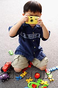 AsiaPix - Young boy playing with toy camera, holding in front of his face